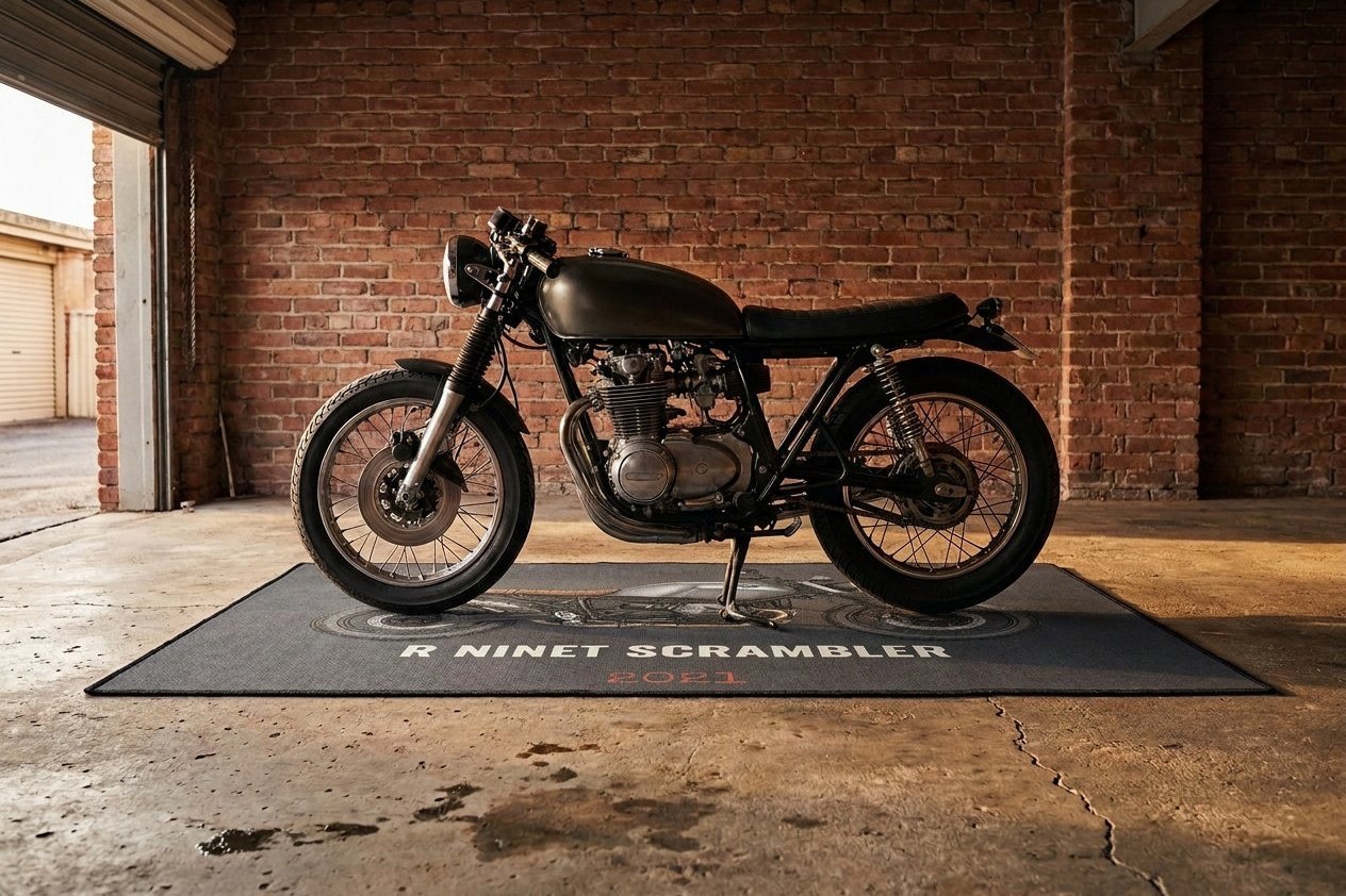 The mat is built to be parked on — drips, boots and a centre stand